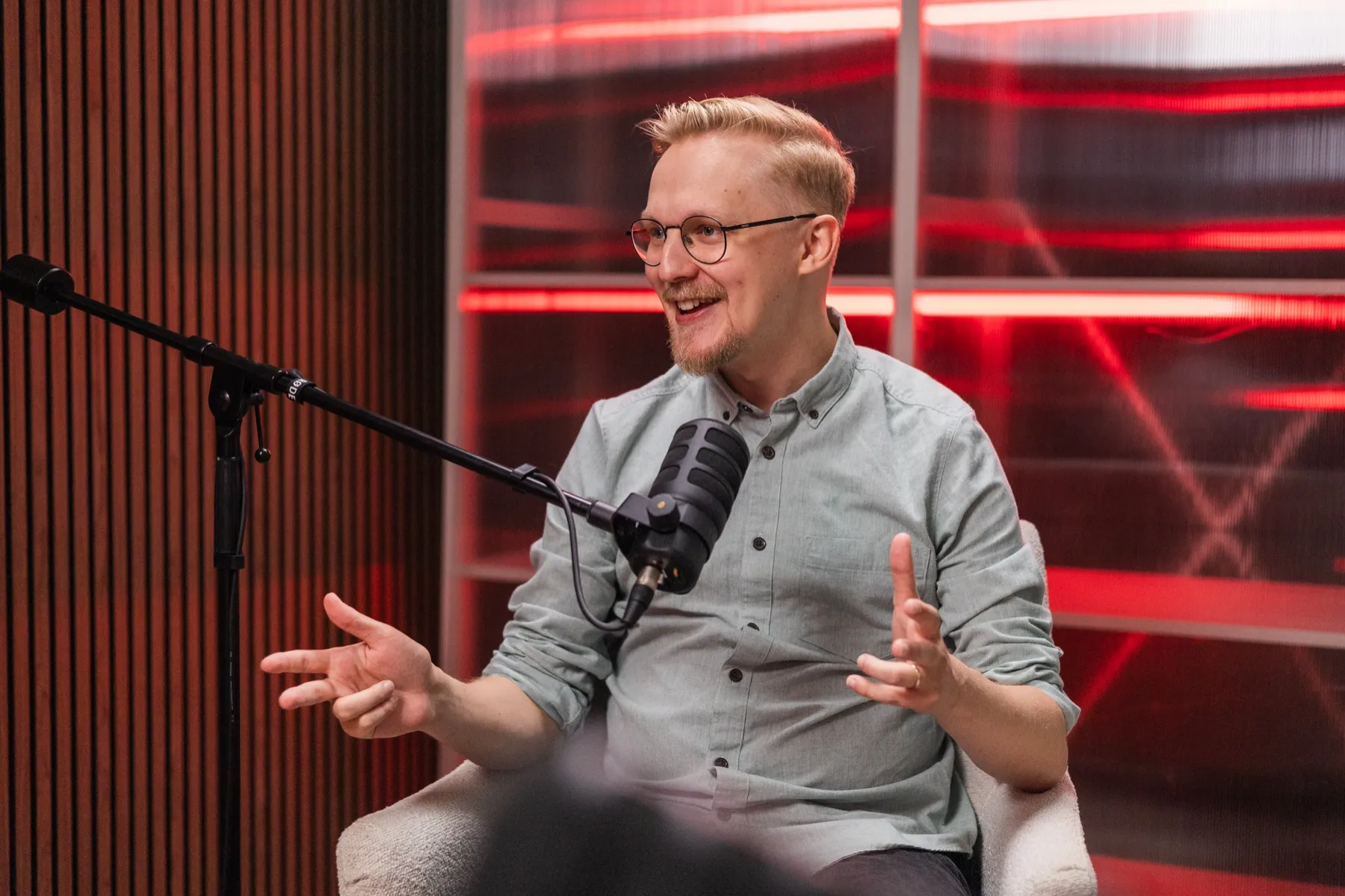 Otso Karvinen mid-sentence, speaking in a podcast studio